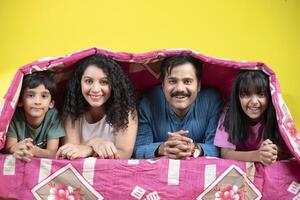 Playful Family With Children In Bed Under A Blanket photo