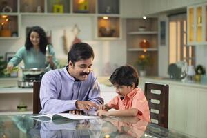 Father Teaching Son With Math Homework At Table photo