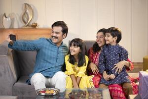 Father And Mother With Kids Taking Pictures With Mobile Phone At Home photo