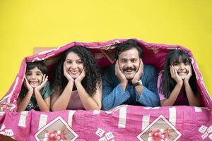 Happy Family Lying Under A Bedsheet photo