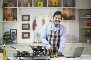 Elegant Male Posing While Cutting Vegetable In Front Of Camera photo