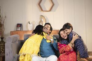 Happy Indian Family Of Four Hugging Spending Time Together At Home photo