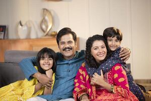 Nuclear Family In Taditional Wear Posing In Front Of Camera photo