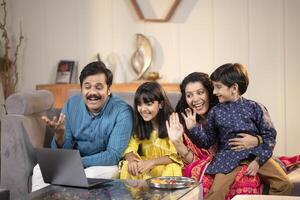 Smiling Family Chatting With Friends By Call On Raksha Bandhan At Home photo