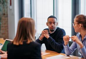 In the vibrant ambiance of a modern startup office, a diverse team of business professionals engage in discussions on various projects and develop new business strategies, epitomizing creativity and photo
