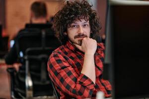 Focused Programmer With Afro Hairstyle in Plaid Shirt Working on Computer in Office Environment photo