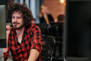 Focused Programmer With Afro Hairstyle in Plaid Shirt Working on Computer in Office Environment photo