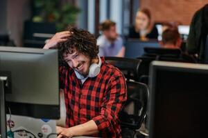 Focused Programmer With Afro Hairstyle in Plaid Shirt Working on Computer in Office Environment photo