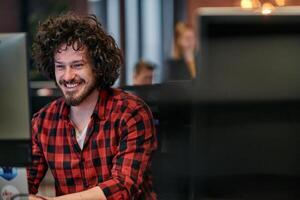 Focused Programmer With Afro Hairstyle in Plaid Shirt Working on Computer in Office Environment photo