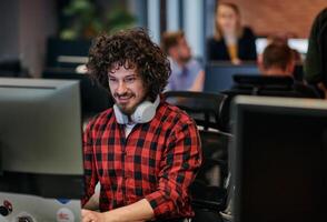 Focused Programmer With Afro Hairstyle in Plaid Shirt Working on Computer in Office Environment photo