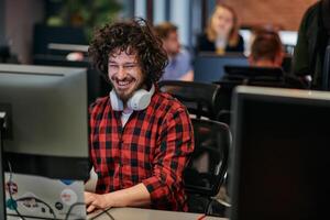 Focused Programmer With Afro Hairstyle in Plaid Shirt Working on Computer in Office Environment photo