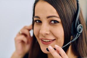 Friendly Call Center Agent Answering Incoming Calls with Headset Providing Remote Customer Service. photo