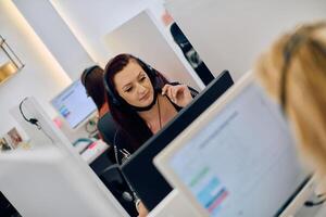 Friendly Call Center Agent Answering Incoming Calls with Headset Providing Remote Customer Service. photo