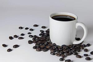 White coffee mug mockup with coffee beans on wooden table. photo