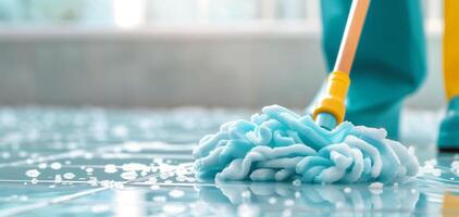 A close-up of a mop cleaning a shiny floor with soap bubbles, showcasing effective cleaning in a bright environment. photo