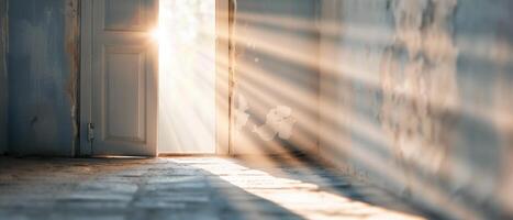 Sunlight streaming through an open door into an empty room, creating dramatic light beams and shadows on the floor and walls. photo