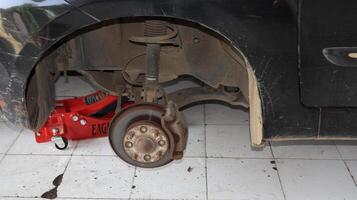 Mechanic changing a wheel of a modern car in a workshop photo