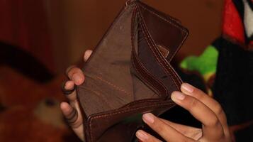 An Empty wallet in the hands of a young photo