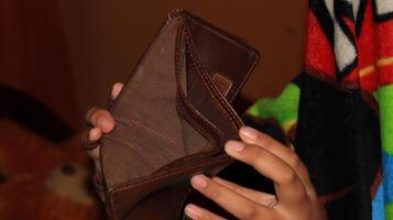 An Empty wallet in the hands of a young photo