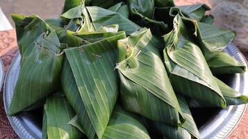 stack of traditional wrapped rice in banana leaves photo