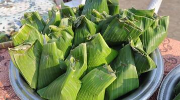 stack of traditional wrapped rice in banana leaves photo