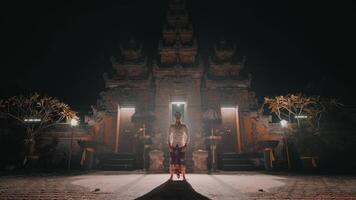 Person standing in front of illuminated temple at night video