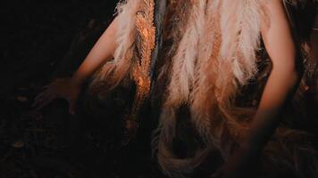 Hand touching dark surface with feathers and fabric video