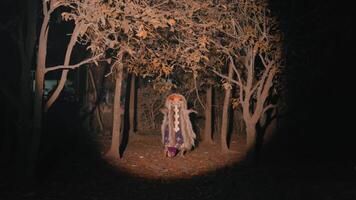 Person in colorful costume in forest at night video