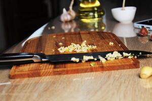 Finely chopped garlic on the kitchen board. The Process of Making Garlic Hot Butter photo
