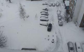 Cars in the snow top view. snow-covered paths and trees photo
