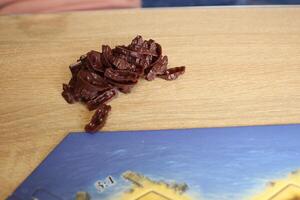 brown meeple game elements on a beige background near the playing field catan photo