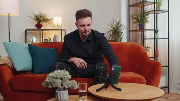 Man blogger looks at device screen taking selfie on smartphone make virtual dance content video