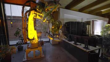 A powerful industrial robot arm engaged in performing complex tasks in a modern workshop environment. Ideal for showcasing advancements in robotics and automation technology video