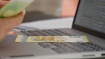 Macro shot of euros being laid on a laptop keyboard female in office. video