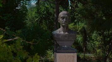 Statue of George Sebastian from ancient era on alley with palm trees. video