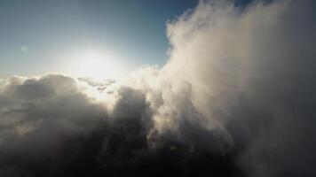 Aerial view Flying over the clouds timelapse with daytime sun. Flying through moving clouds with beautiful reflections. Air travel. Ideal for cinema, background video