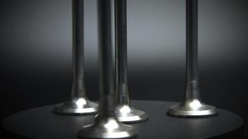 New internal combustion engine valves on a rotating platform on a black background. Spare parts for internal combustion engines of cars video