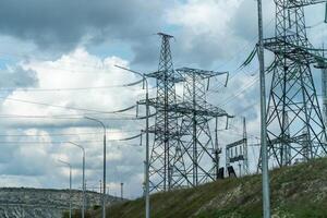 High voltage towers with sky background. Power line support with wires for electricity transmission. High voltage grid tower with wire cable at distribution station. Energy industry, energy saving photo