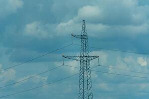 High voltage towers with sky background. Power line support with wires for electricity transmission. High voltage grid tower with wire cable at distribution station. Energy industry, energy saving photo