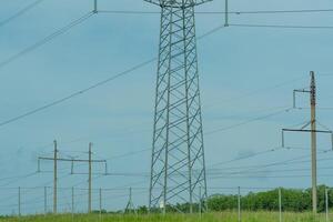 High voltage towers with sky background. Power line support with wires for electricity transmission. High voltage grid tower with wire cable at distribution station. Energy industry, energy saving photo