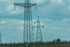 High voltage towers with sky background. Power line support with wires for electricity transmission. High voltage grid tower with wire cable at distribution station. Energy industry, energy saving photo