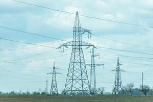 High voltage towers with sky background. Power line support with wires for electricity transmission. High voltage grid tower with wire cable at distribution station. Energy industry, energy saving photo