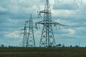 High voltage towers with sky background. Power line support with wires for electricity transmission. High voltage grid tower with wire cable at distribution station. Energy industry, energy saving photo