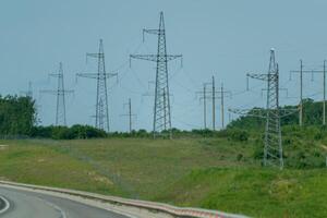 High voltage towers with sky background. Power line support with wires for electricity transmission. High voltage grid tower with wire cable at distribution station. Energy industry, energy saving photo