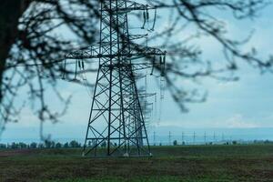 High voltage towers with sky background. Power line support with wires for electricity transmission. High voltage grid tower with wire cable at distribution station. Energy industry, energy saving photo