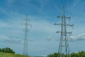 High voltage towers with sky background. Power line support with wires for electricity transmission. High voltage grid tower with wire cable at distribution station. Energy industry, energy saving photo