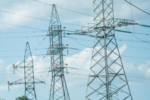 High voltage towers with sky background. Power line support with wires for electricity transmission. High voltage grid tower with wire cable at distribution station. Energy industry, energy saving photo