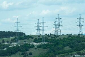 High voltage towers with sky background. Power line support with wires for electricity transmission. High voltage grid tower with wire cable at distribution station. Energy industry, energy saving photo