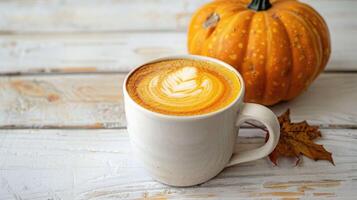 Hot pumpkin latte with delicious foam, on a white wooden tabletop. Delicious milky autumn, winter pumpkin drink photo