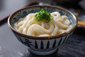 Japanese udon noodles in a bowl on a wooden table close up photo